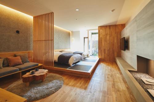 厚木Seirakuen的一间卧室配有一张床、一张沙发和一台电视。