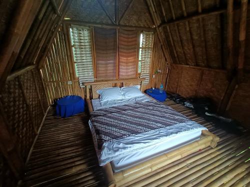 特特巴图Girang Rinjani Bungalows的木制客房内的一间卧室,配有一张床