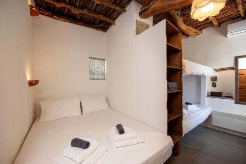 RalakiGiourgas Cottage Milos Island的卧室配有白色床和毛巾