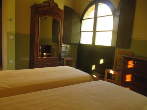 卡利Agriturismo Serracanina的一间卧室设有两张床、镜子和窗户
