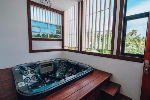FuvahmulahMillennium Island Residence的浴缸位于带2扇窗户的房间内