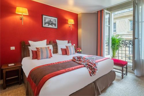 巴黎特里亚农左岸酒店的一间卧室设有一张红色墙壁的大床