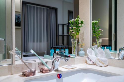广州广州维多利酒店的浴室的柜台设有水槽和镜子