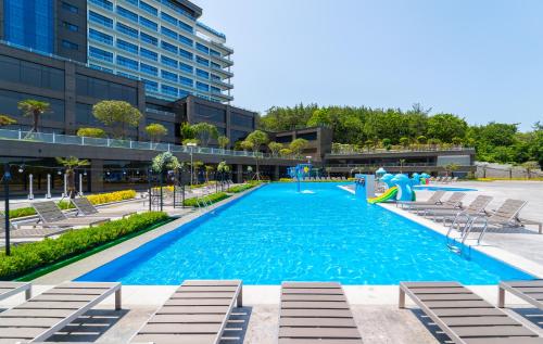 丽水市Hotel JCS Yeosu的一座大型游泳池,里面的人跳进游泳池