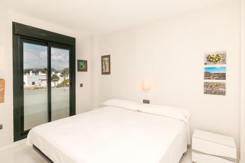 卡萨雷斯2207-Modern apt with terrace and amazing seaview的白色的卧室设有白色的床和窗户。