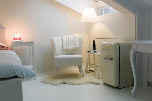 米德尔堡B&B De Kloostertuin的白色的客房设有椅子和冰箱