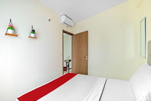 茂物Skyland Podomoro Golf View Apartemen的卧室配有一张带红色毯子的白色床