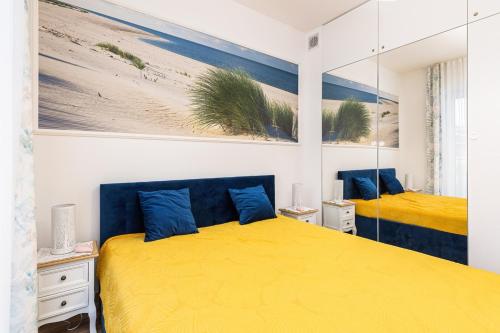 里沃Apartament Holiday 8/25的一间卧室配有两张带黄床单和蓝色枕头的床。