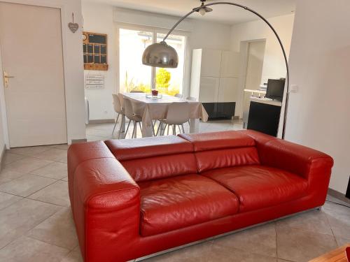 安德诺莱斯贝恩Villa clair logis的客厅里一张红色的皮沙发,配有桌子