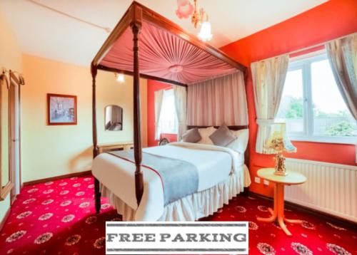泰恩河畔纽卡斯尔OYO The Royal Hotel的一间红色客房内的卧室,配有一张天蓬床