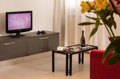 威尼斯佩里格里诺商业酒店的客厅配有桌子和电视