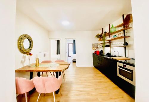 马略卡岛帕尔马Hotel Apartment with 2-en suite Bedrooms的厨房配有木桌和粉红色的椅子