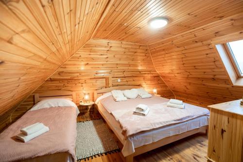 拉科维察Chalet Markoci With Hot Tub - Happy Rentals的小木屋内一间卧室,配有两张床