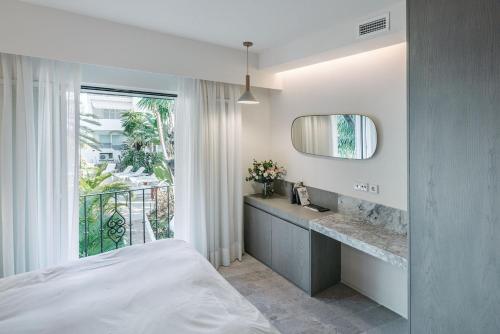 马贝拉Puente Romano Beach Suites - private apartaments的一间卧室配有床、水槽和窗户