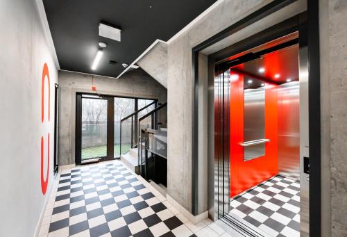 华沙Bohema Place - Metro Szwedzka Apartment的走廊上设有红色的门和 ⁇ 格地板
