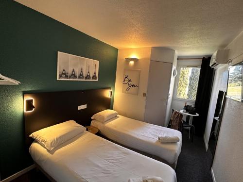 阿莱斯L'Escale d'Alès HOTEL的酒店客房设有两张床和绿色的墙壁。