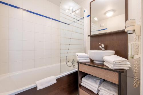 安锡Zenitude Hôtel-Résidences Les Hauts d'Annecy的浴室配有盥洗盆和浴缸。