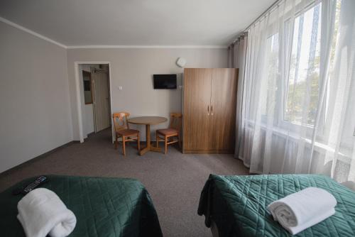 克拉科夫费利克斯酒店的一间卧室配有一张床、一张桌子和一个窗户。