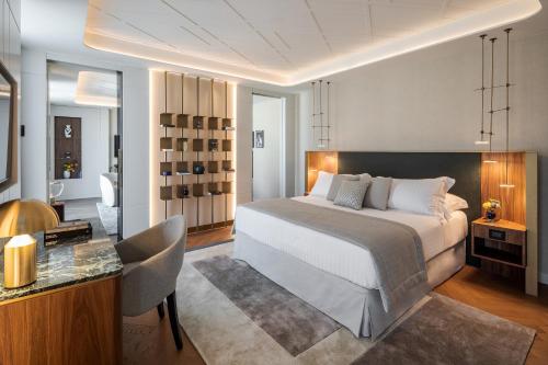 米兰Casa Baglioni Milan - The Leading Hotels of the World的一间卧室配有一张床和一张桌子及椅子