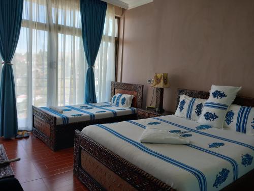 拉利贝拉Blue Nile Guest House的蓝色和白色的客房内的两张床