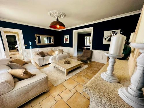 Prignac-et-MarcampsDomaine des Hugons的客厅配有沙发和桌子