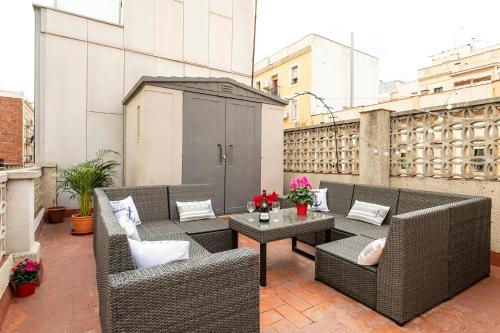 巴塞罗那Barcelona Beach Home的阳台的庭院配有藤椅和桌子