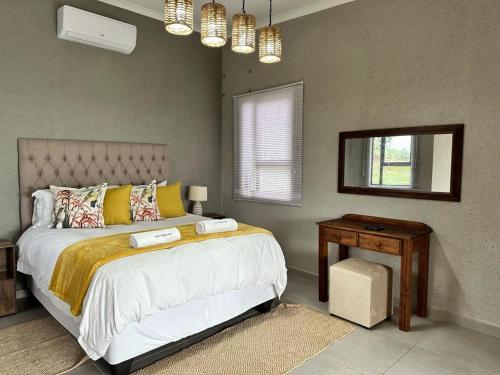 雾观Hazyview Accommodation, Bon Repose Cottages 3&4的一间卧室配有一张大床和镜子