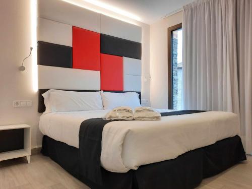 艾因萨Apartamentos Ordesa Ainsa的一间卧室配有一张大床和色彩缤纷的床头板