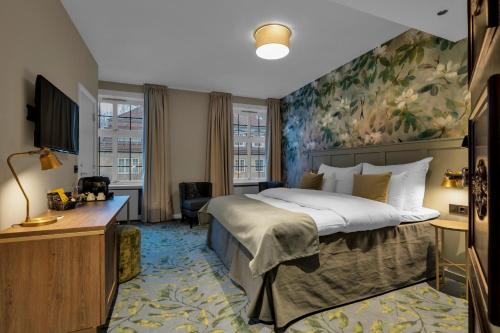 奥斯陆贾贝尔胡斯克拉丽奥连锁酒店的卧室配有一张大床,墙上挂有绘画作品