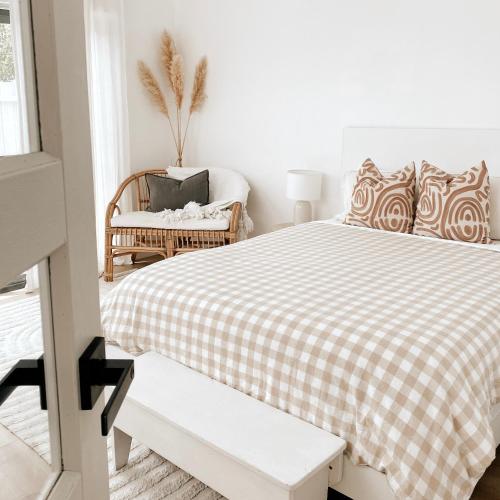 沃纳姆堡The Hideaway - Guest House的白色卧室配有床和椅子