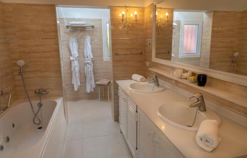 埃尔帕索La Palma Jardín Resort的浴室配有两个盥洗盆、浴缸和浴缸。
