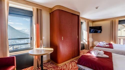 沃雅尼Madame Vacances Hotel Les Cimes的酒店客房设有两张床和窗户。