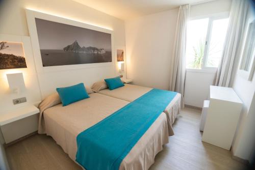 普拉亚登博萨波拉波拉公寓 - 仅限成人的一间卧室配有一张带蓝色枕头的大床