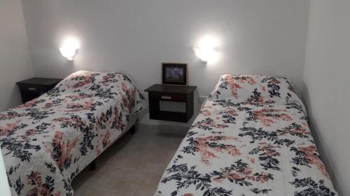 瓜莱瓜伊Alojamiento Guemes的一间卧室设有两张床和两个床头柜
