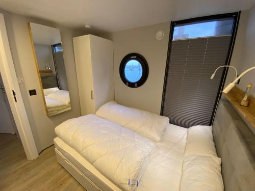 温德托尔夫Hausboot Fjord Luna mit Biosauna in Wendtorf的一间小卧室,配有床和窗户