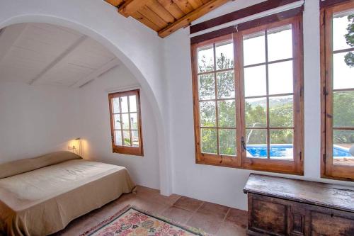 科贝拉罗布里加Catalunya Casas Majestic Villa and Views , 30km to Barcelona的一间卧室设有一张床和两个窗户。