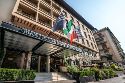 佛罗伦萨FH55 Grand Hotel Mediterraneo的前面有三面旗帜的酒店