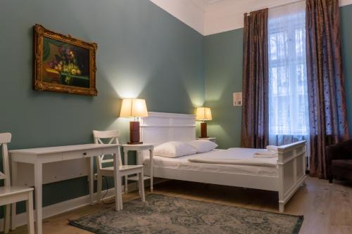柏林奥利维尔广场公寓式酒店的一间卧室配有一张床、一张书桌和一个窗户。