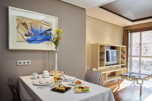 巴利亚多利德奈克萨斯巴利亚多利德套房酒店的用餐室配有餐桌和食物
