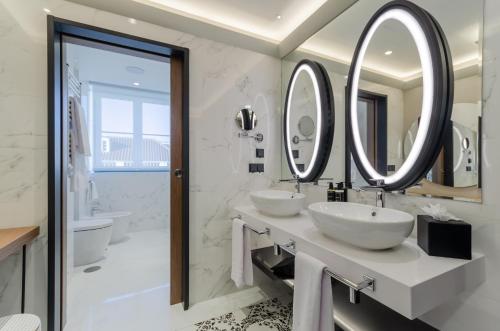 里斯本Eurostars Lisboa Baixa的浴室设有2个水槽和2面镜子