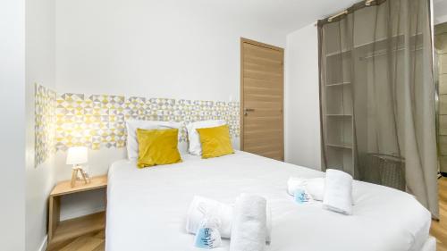 福龙河畔拉罗什HOMEY SNOW - Proche Gare - Balcon privé - Wifi的卧室配有一张带黄色枕头的大型白色床。