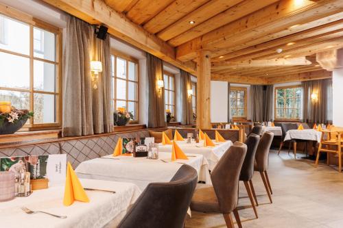 克拉姆萨赫兰芳格派酒店的餐厅设有白色的桌椅和窗户。