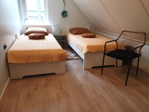 WilpBij de oude dijk的一间卧室配有两张床和椅子
