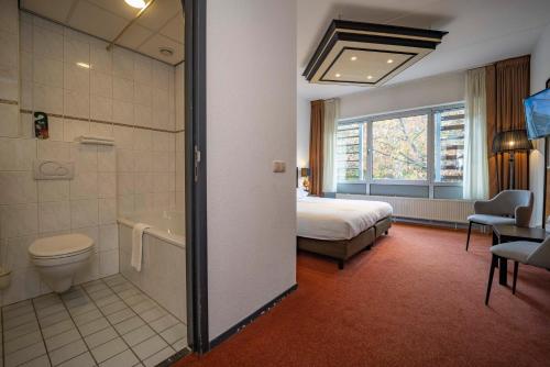 阿珀尔多伦阿培尔顿弗莱彻酒店的酒店客房设有一张床和一间带浴缸的浴室。