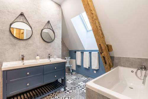 克莱蒙莱斯弗蒙Gite La Petite Ferme的一间带水槽、浴缸和镜子的浴室