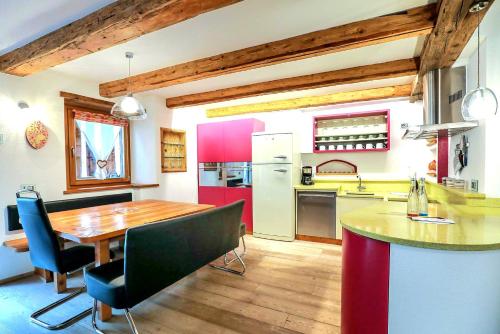 卡纳泽伊Chalet Tobià的一间带木桌的厨房和一间餐厅