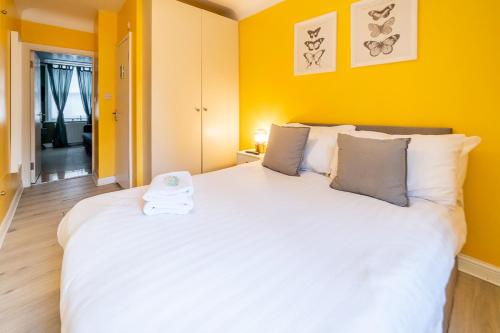 伦敦[COVENT GARDEN] Apartment in Central London的卧室设有一张白色大床和黄色的墙壁
