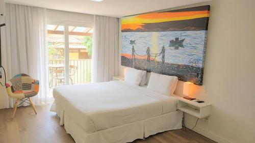布希奥斯Parador Búzios Boutique Hotel的卧室配有一张床,墙上挂有绘画作品