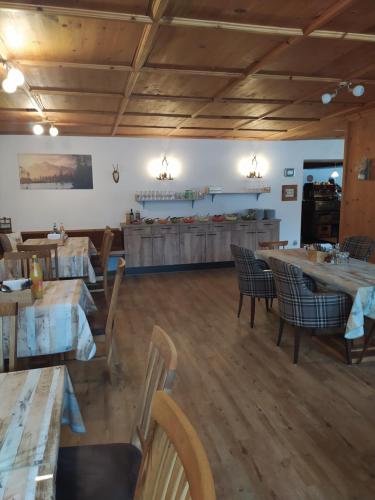 坎波图雷斯Appartments Waldblick的餐厅铺有木地板,配有桌椅