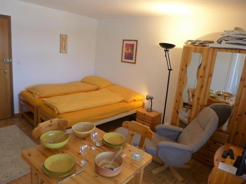维尔马拉Apartment Cransalpin-4 by Interhome的一间卧室配有床和一张桌子,上面有盘子